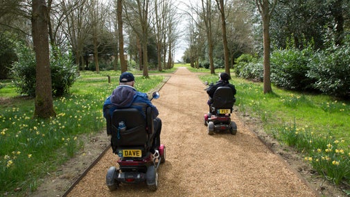 Visitors with mobility scooters in the park at Blickling Estate, Norfolk